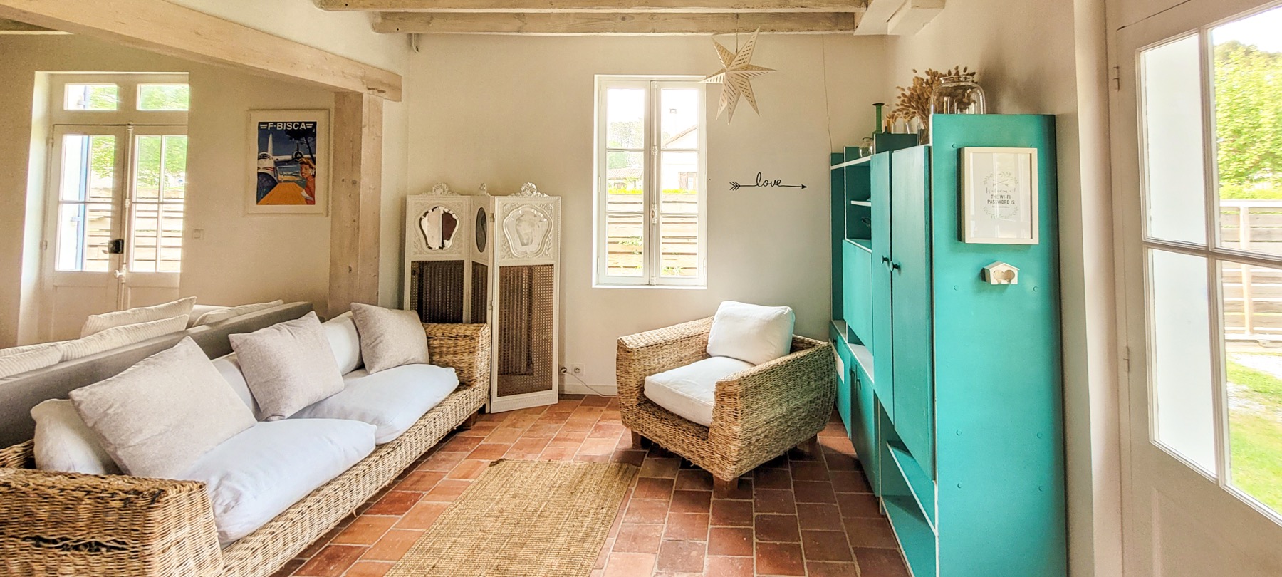 Salon secondaire meuble turquoise canapé rotin