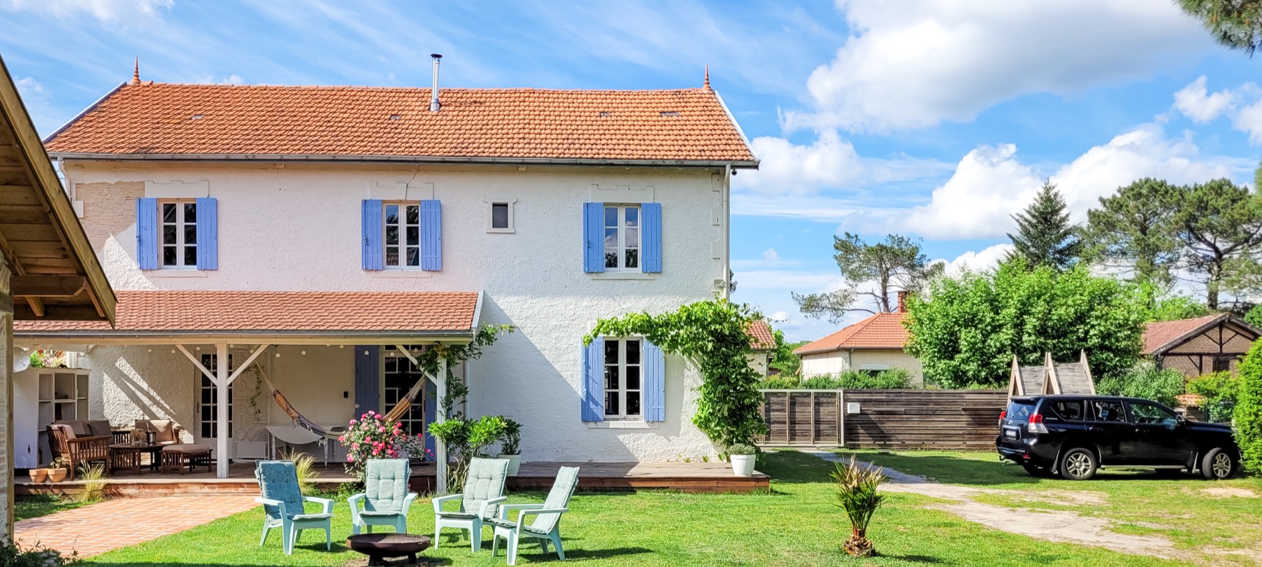 Jardin maison brasero volets bleus pelouse